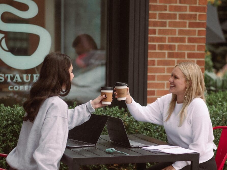 Two girls cheers there coffee outside of Stauf's near OSU