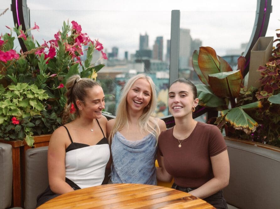 3 girls on a rooftop smiling and happy near OSU