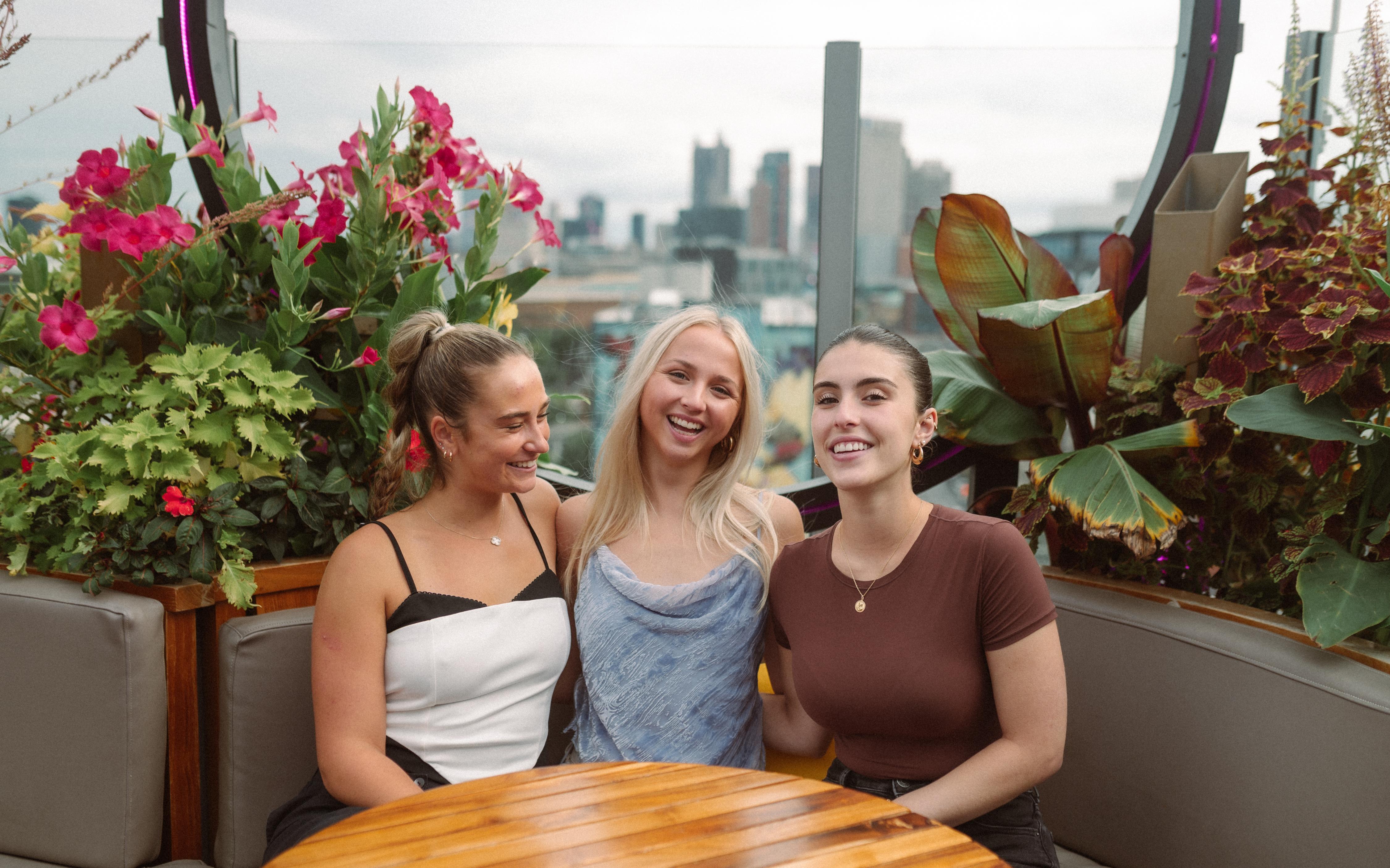 3 girls on a rooftop smiling and happy near OSU