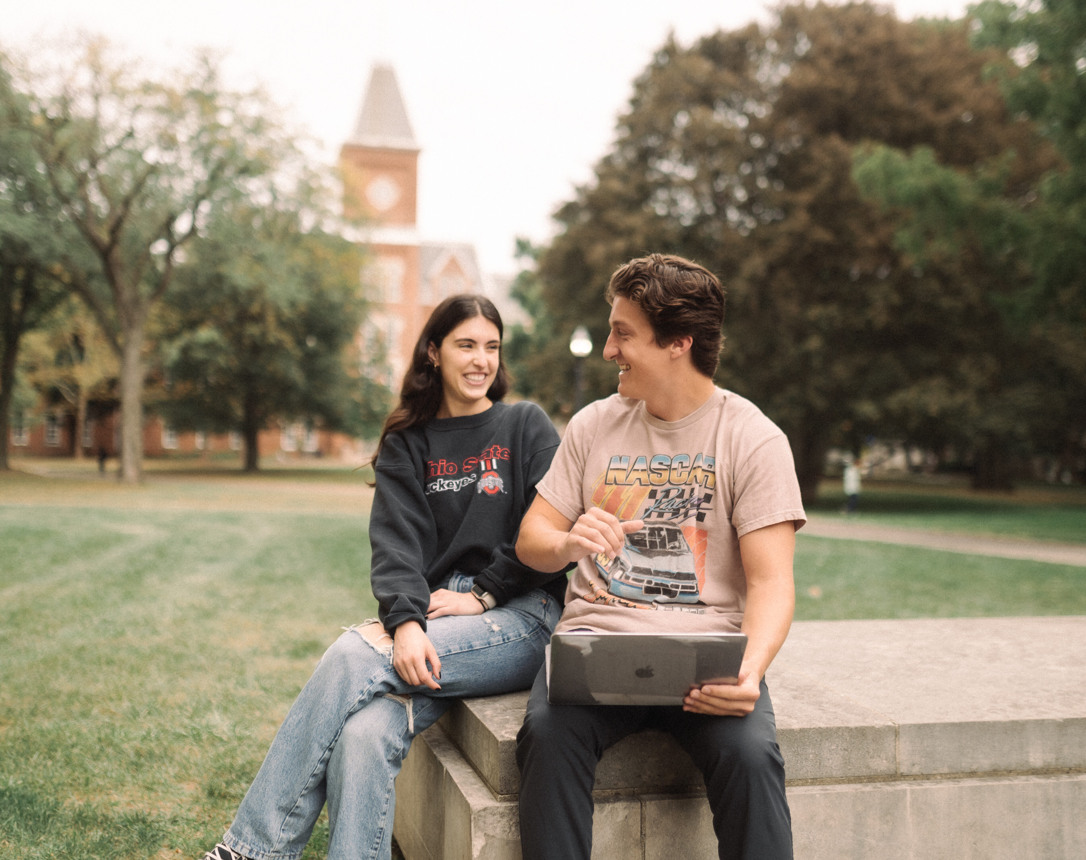 two people outside thompson library on the osu oval looking at a computer