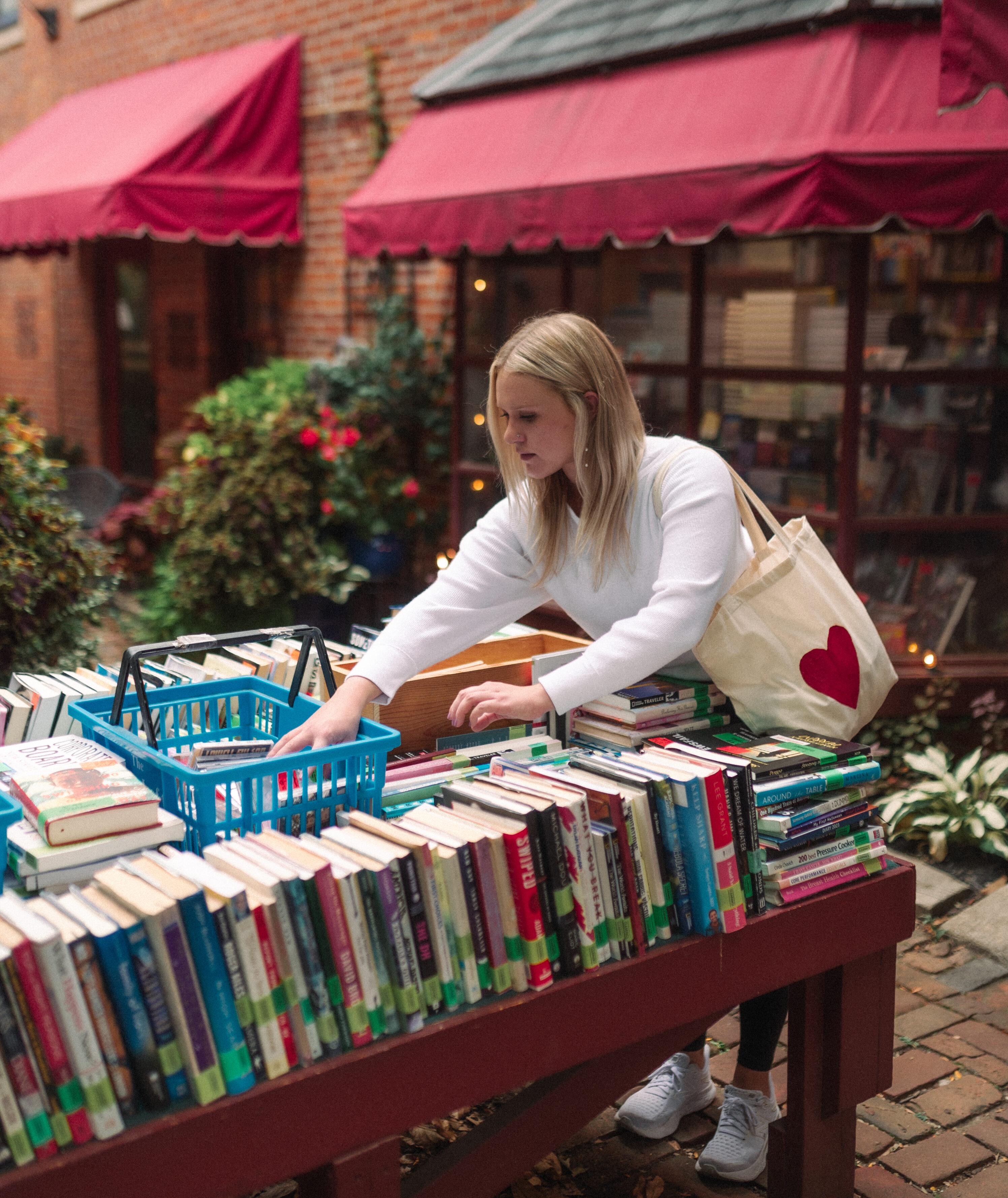 girl sorting through books in german village at the book loft
