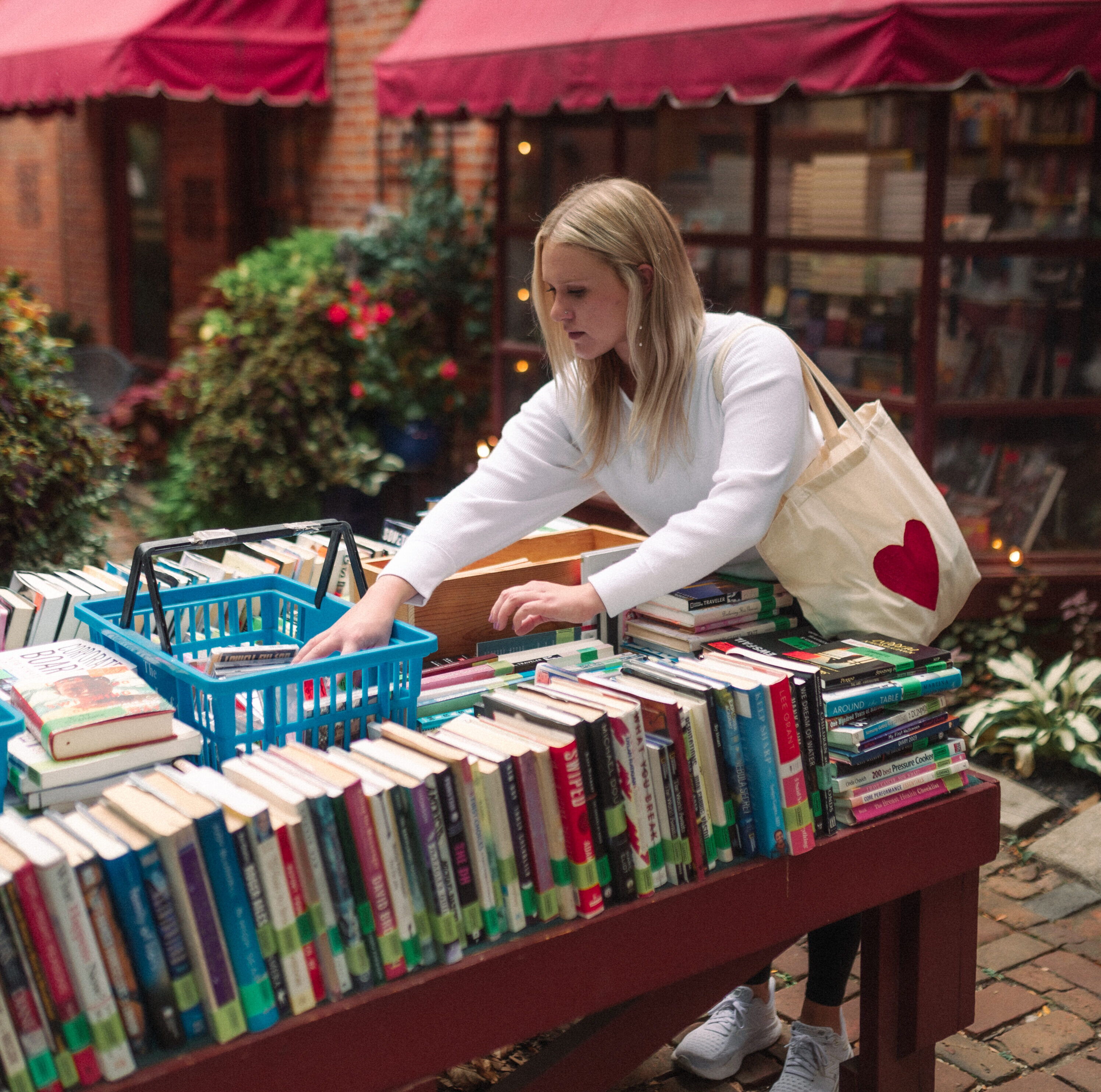 girl sorting through books in german village at the book loft