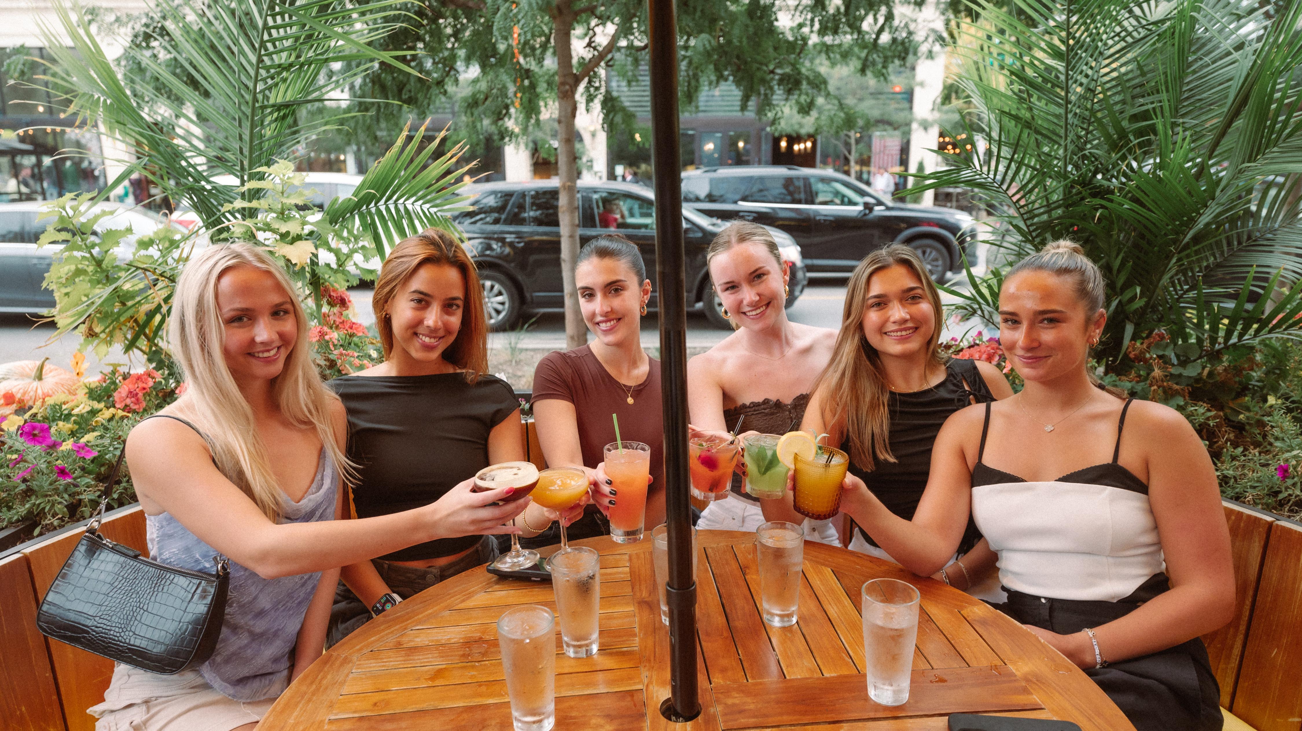 Girls drinking at Townhall doing a cheers in the short north