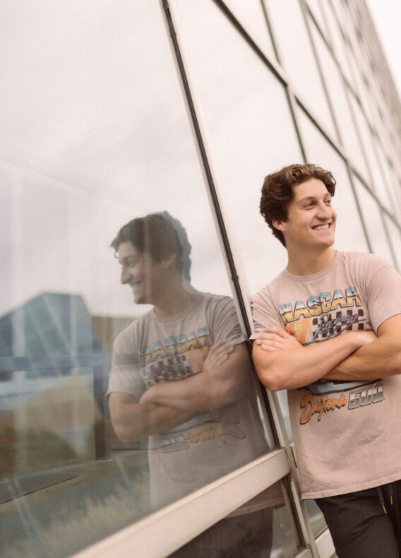boy leaning up against RPAC on ohio states campus