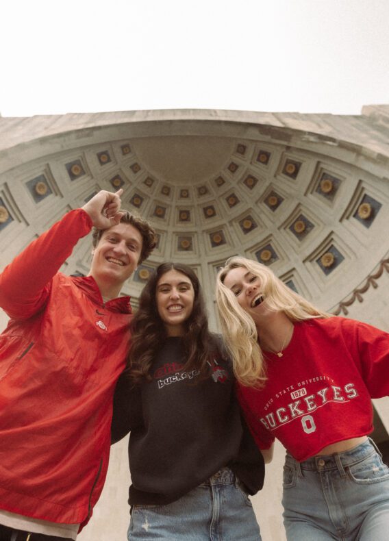 3 students cheering outside the shoe at Ohio State