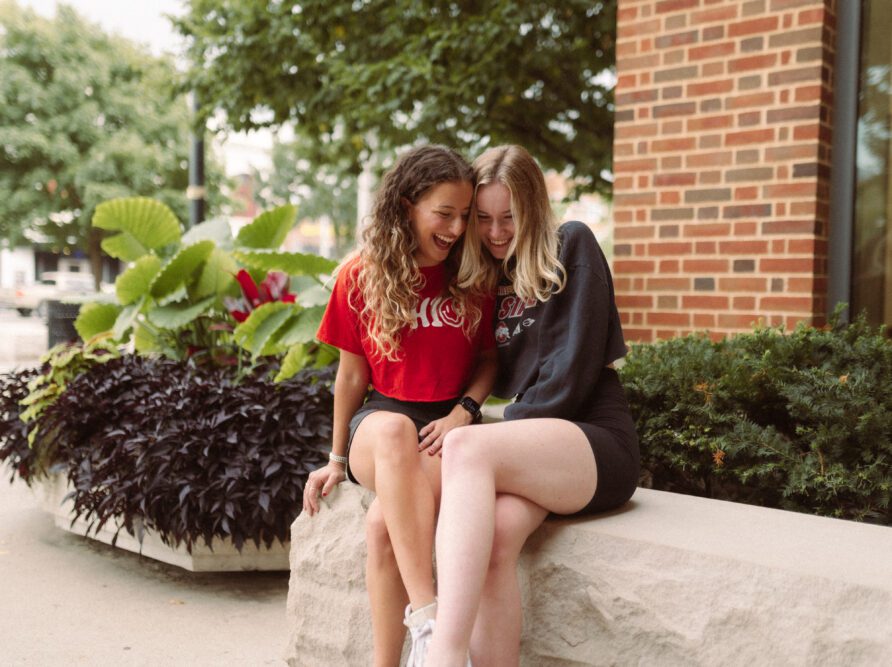 two girls in OSU shirts hugging